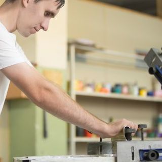 personne en train d'utiliser une machine faisant de la sérigraphie