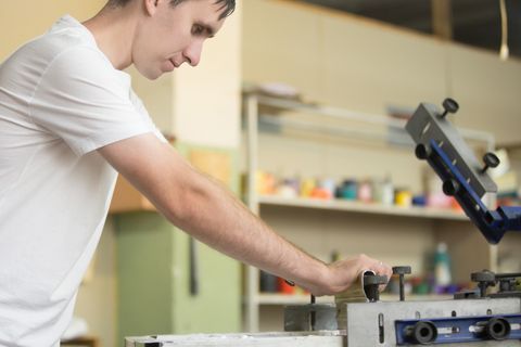 personne en train d'utiliser une machine faisant de la sérigraphie